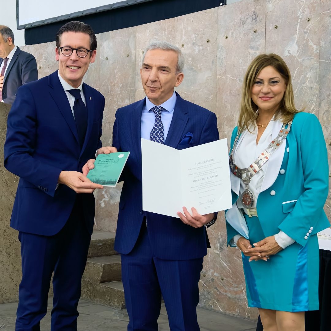 Prof. Dr. Frank E.P. Dievernich und Bürgermeisterin Nargess Eskandari-Grünbergüberreichen eine Auszeichnung an Hulisi Bayam. Foto: Foto: Stadt Frankfurt / Nicolas Det
