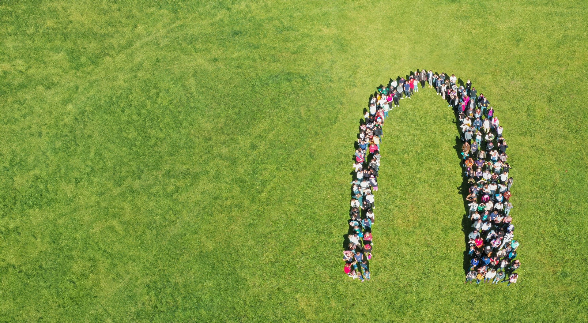 Alumni, Stipendiatinnen und Stipendiaten der Stiftung haben sich auf dem Alumnitag der Stiftung so aufgestellt, dass sie aus der Luft betrachtet das Logo der Stiftung bilden.